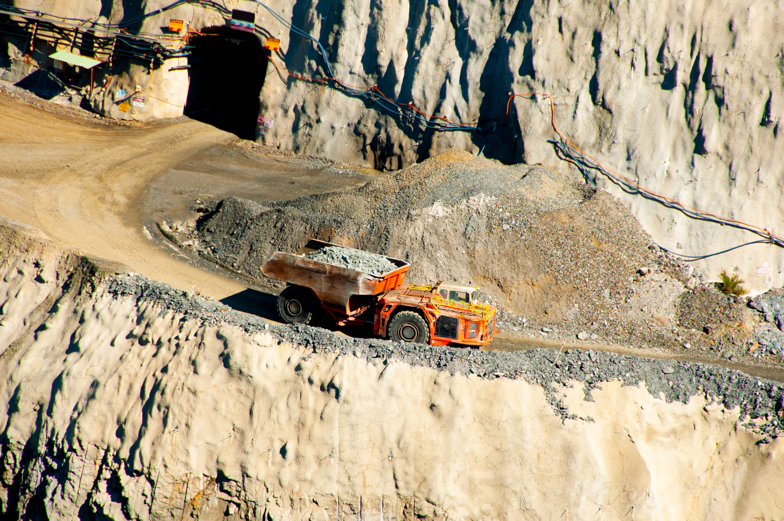 Mining truck with Bost underground truck tub driving on gravel road.